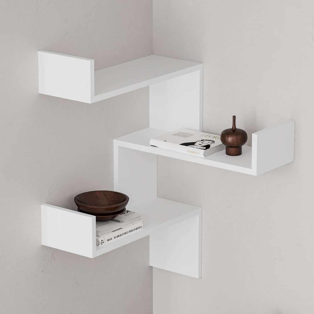 White corner wall-mounted bookcase with three open display shelves in a corner