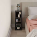 Small low standing bookcase in dark wood with open cubby shelves for books and decor