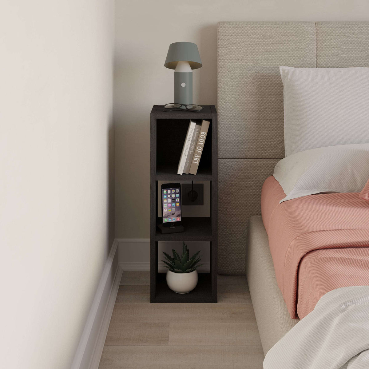 Small low standing bookcase in dark wood with open cubby shelves for books and decor
