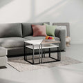 Modern coffee table with white top and black metal frame, styling on a rug