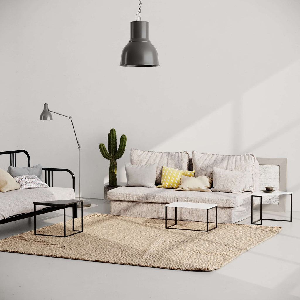Modern coffee table with white top and black metal frame on a beige rug