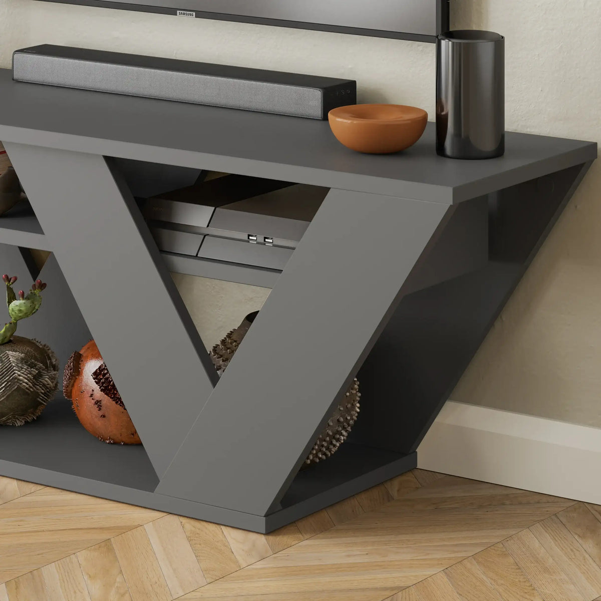 Modern dark grey TV stand with open V shelves and pull-out drawer