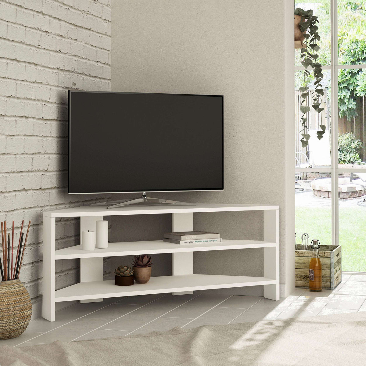 White corner TV stand with open shelves under a flat-screen TV