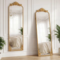 Full length mirror with ornate baroque gold frame, two angles against paneled wall