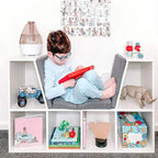 White cube storage shelf with gray cushioned seat, kid playing with toys in cubbies