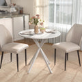 White round dining table with tripod base and four upholstered dining chairs