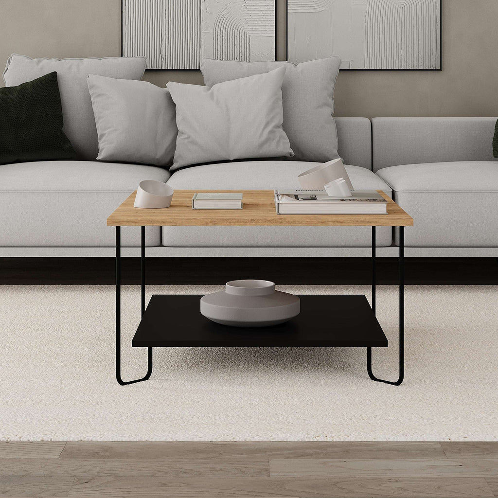 Two-tier coffee table in light oak with black lower shelf and metal legs in living room