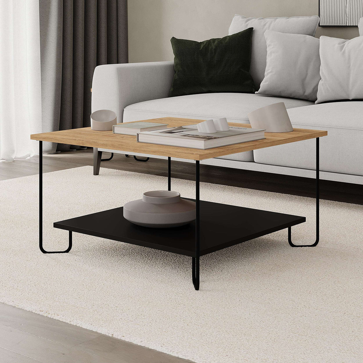 Two-tier coffee table with light oak top and black lower shelf, styled in a living room
