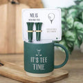 Green mug with 'IT'S TEE TIME' and included golf tees in display card
