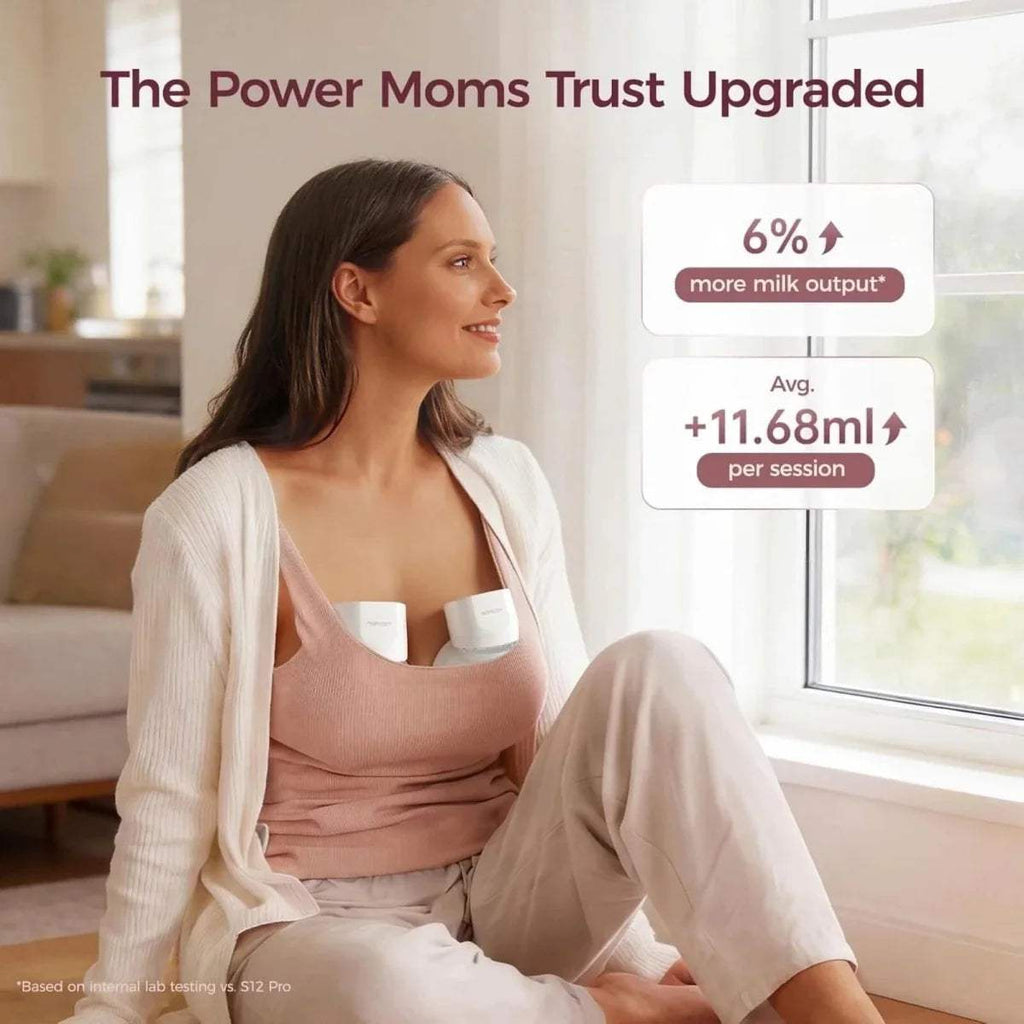 Woman seated with a white wearable electric breast pump fitted over her bra cups