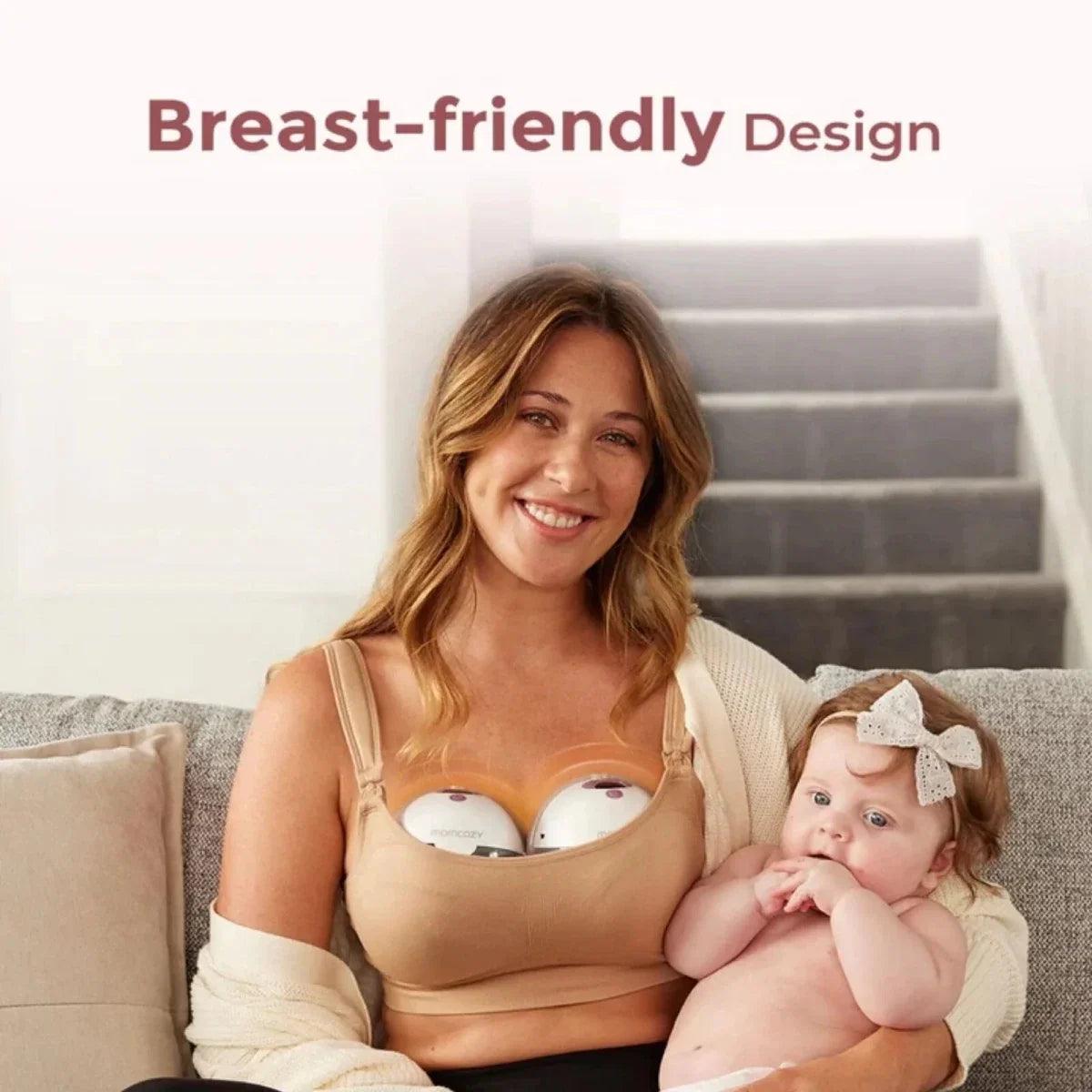 Breast pump bra setup with wearable pump cups on woman holding a baby