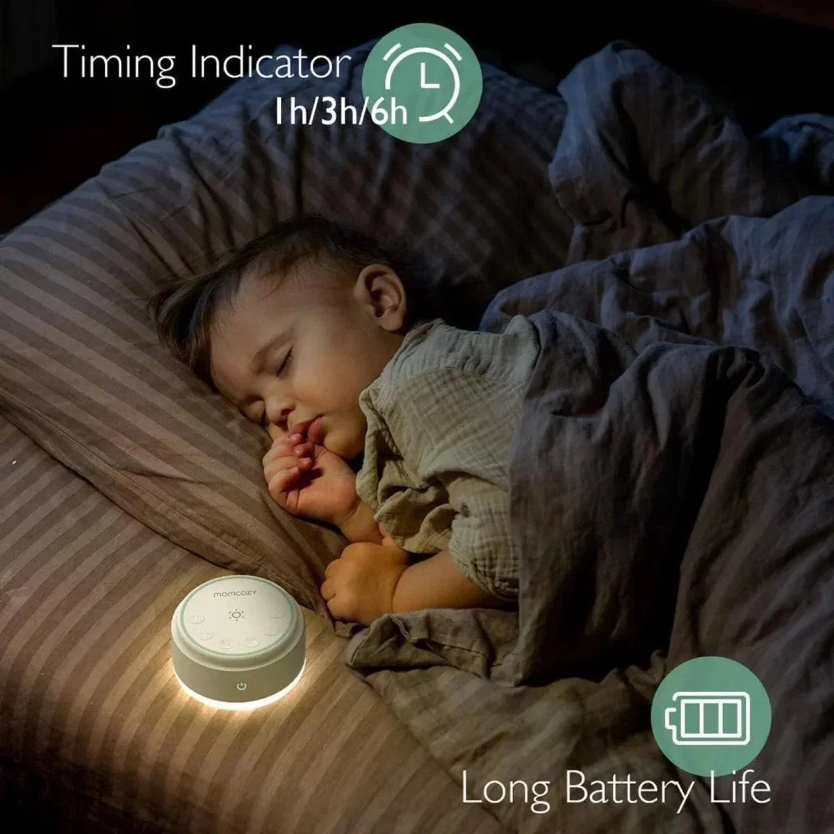 White Momcozy white noise machine on a bedside surface, with power button visible