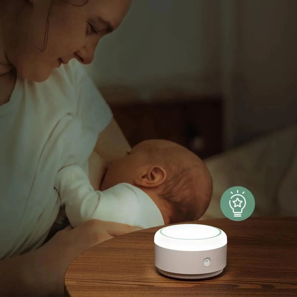 White Momcozy white noise machine on a wooden table with top control panel shown