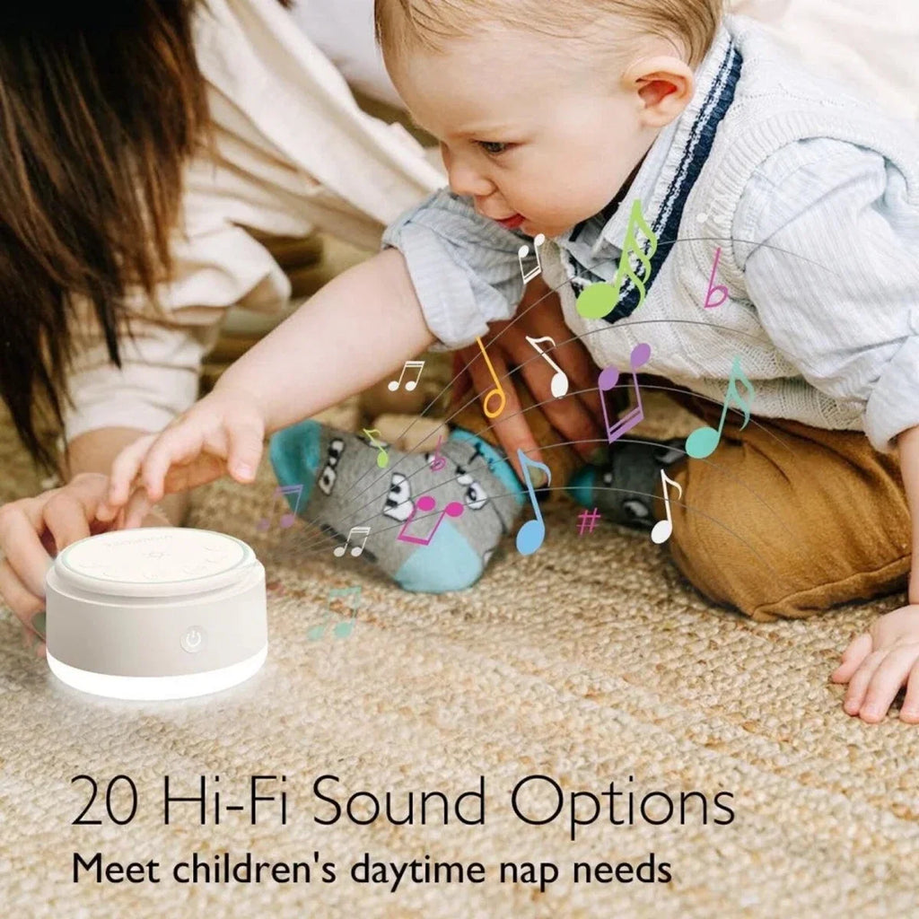 White Momcozy white noise machine on the floor, round with mint-tinted top controls