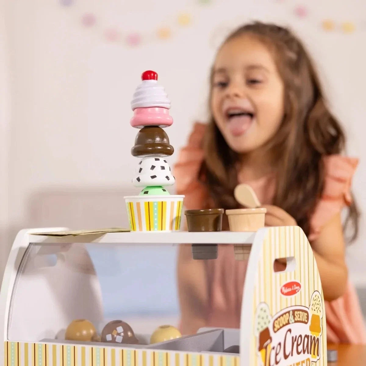 Toy ice cream cone sitting on wooden counter with colorful fry-style sprinkles