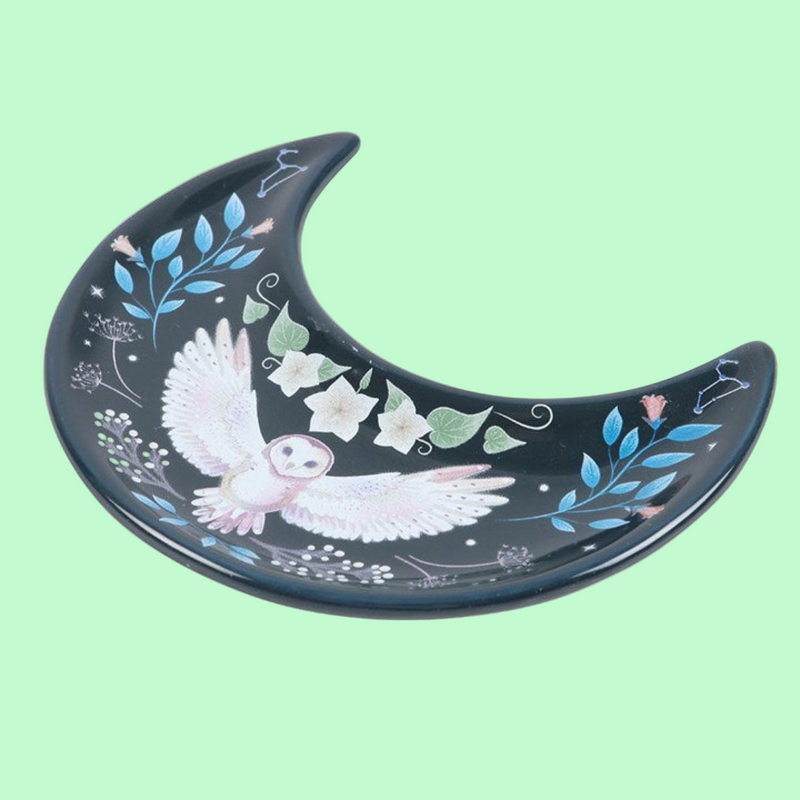 Decorative plate shaped like a crescent moon with an owl and floral design on a white background