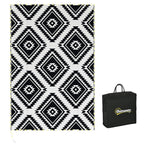 Reversible outdoor rug with black-and-white geometric diamond pattern and LED string lights
