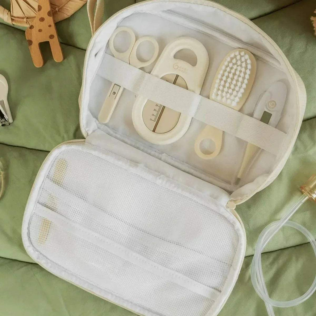 Open baby grooming kit case showing comb, brush, and mesh storage compartments