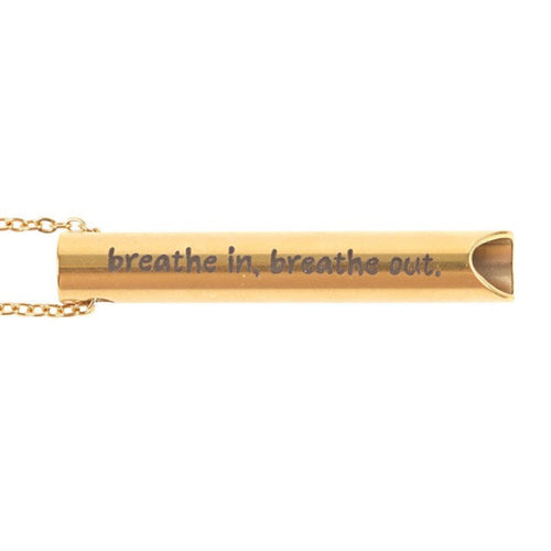 Gold necklace with a bar pendant inscribed with 'breathe in, breathe out' on a white background
