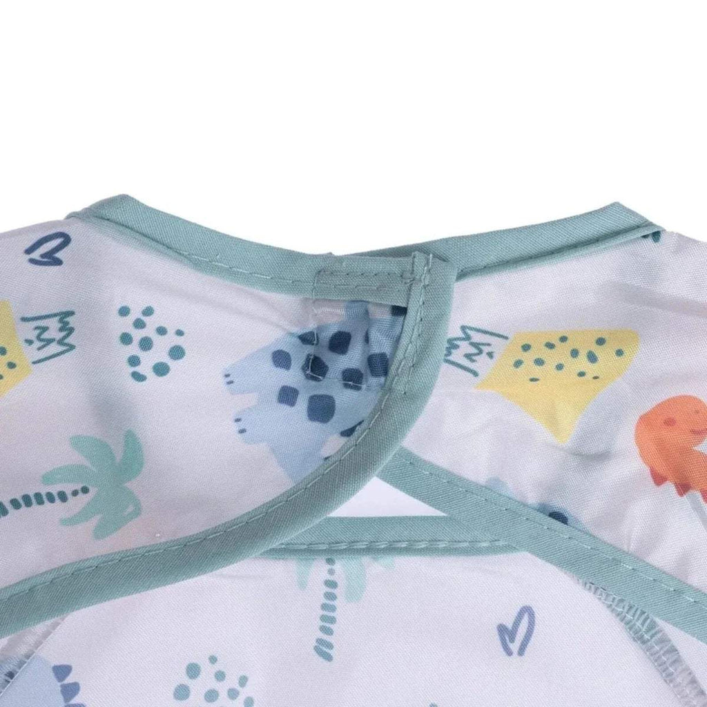 Baby coverall bib neckline detail with light blue binding and dinosaur fabric pattern