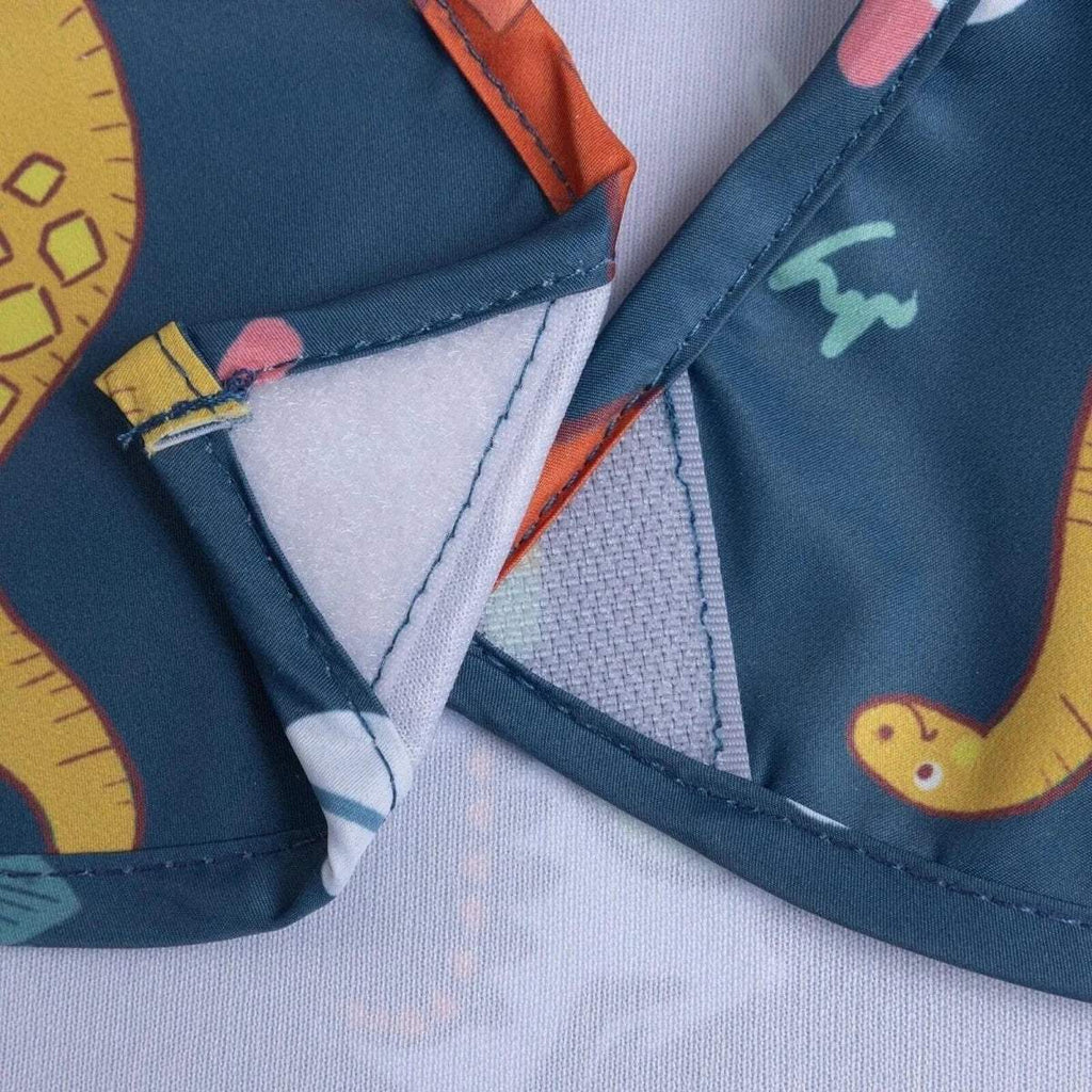 Blue baby bib fastening and stitched edges with dinosaur print on shoulder