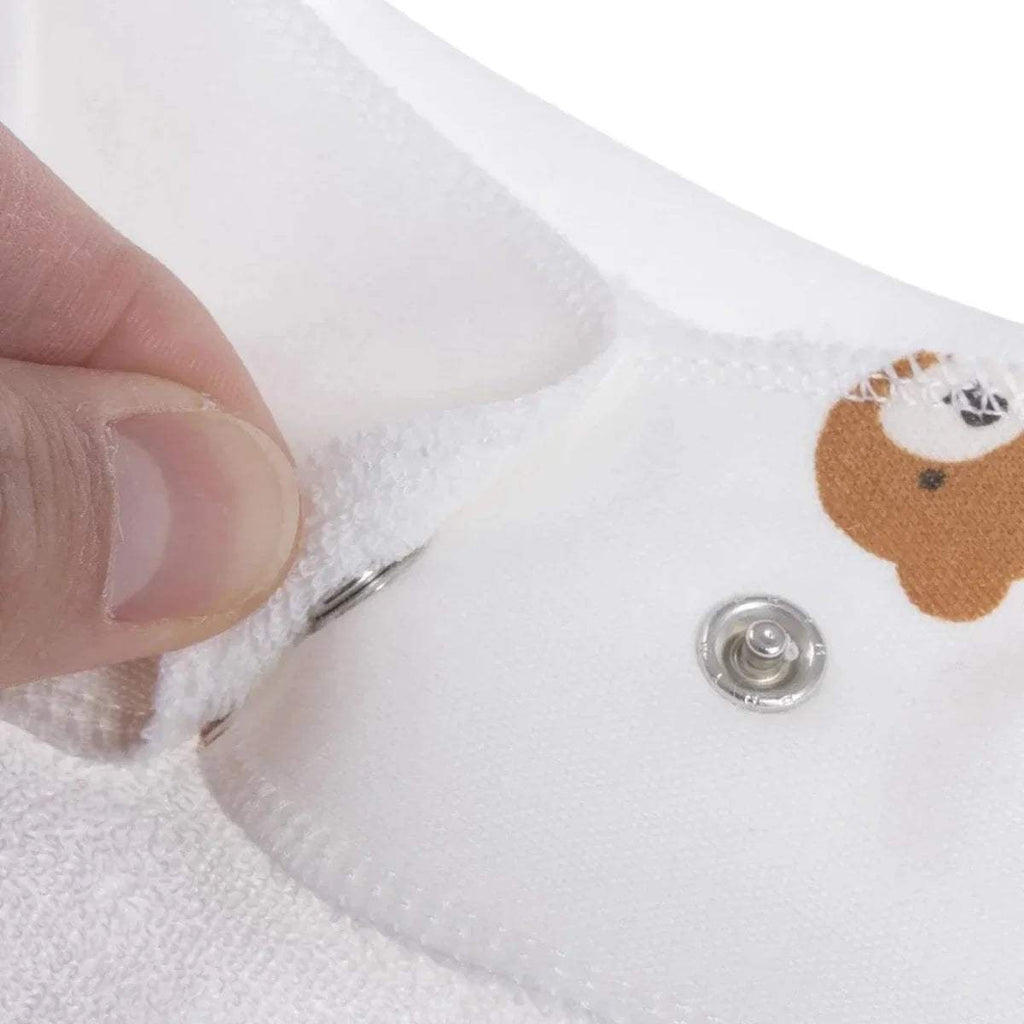 Close-up of white cotton bandana bib snap button and teddy print fabric edge