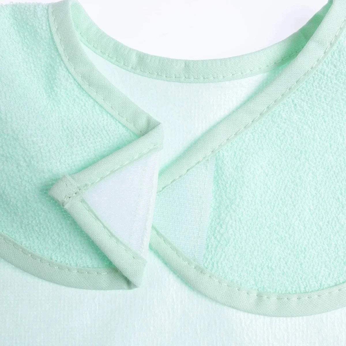 Teal waterproof baby bib close-up of layered fabric and stitched front edge.