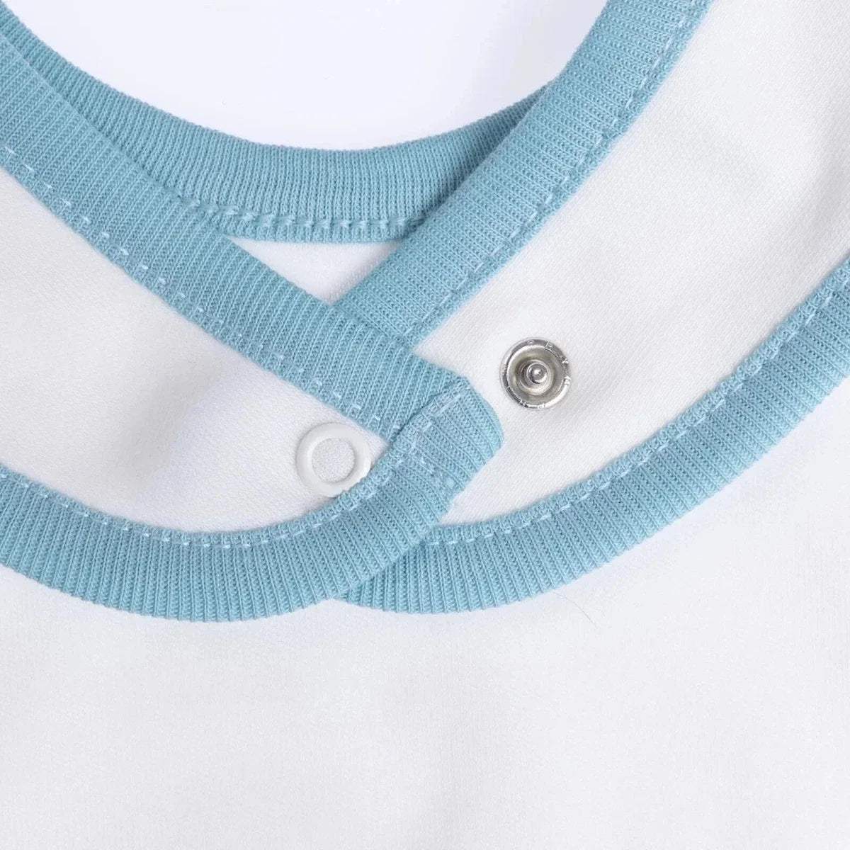 Baby bib neckline close-up with blue rib trim and metal snap buttons