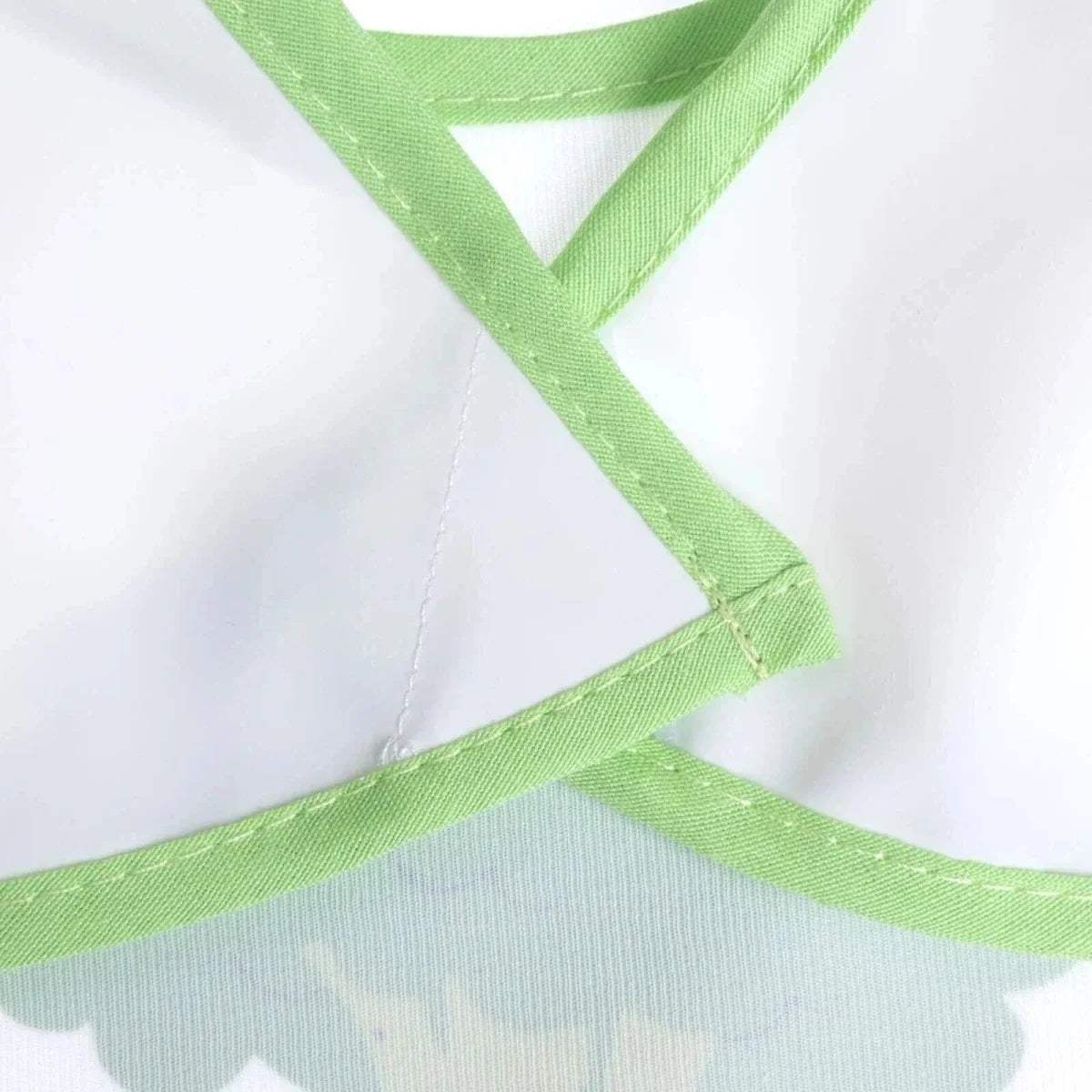 Wipe-clean bib neck strap with crossed green binding and stitched seams