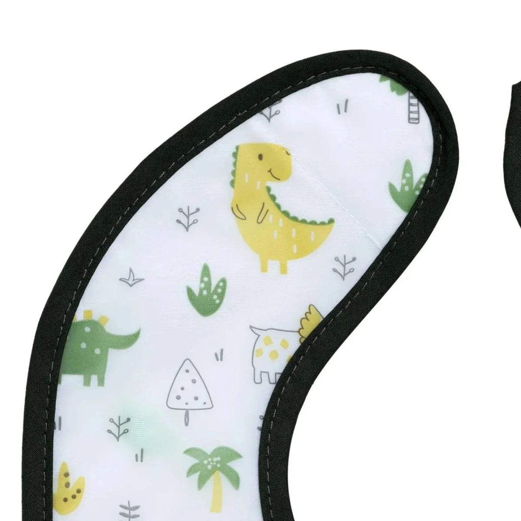 Close-up of white dinosaur baby bib with black edge stitching and playful animal print