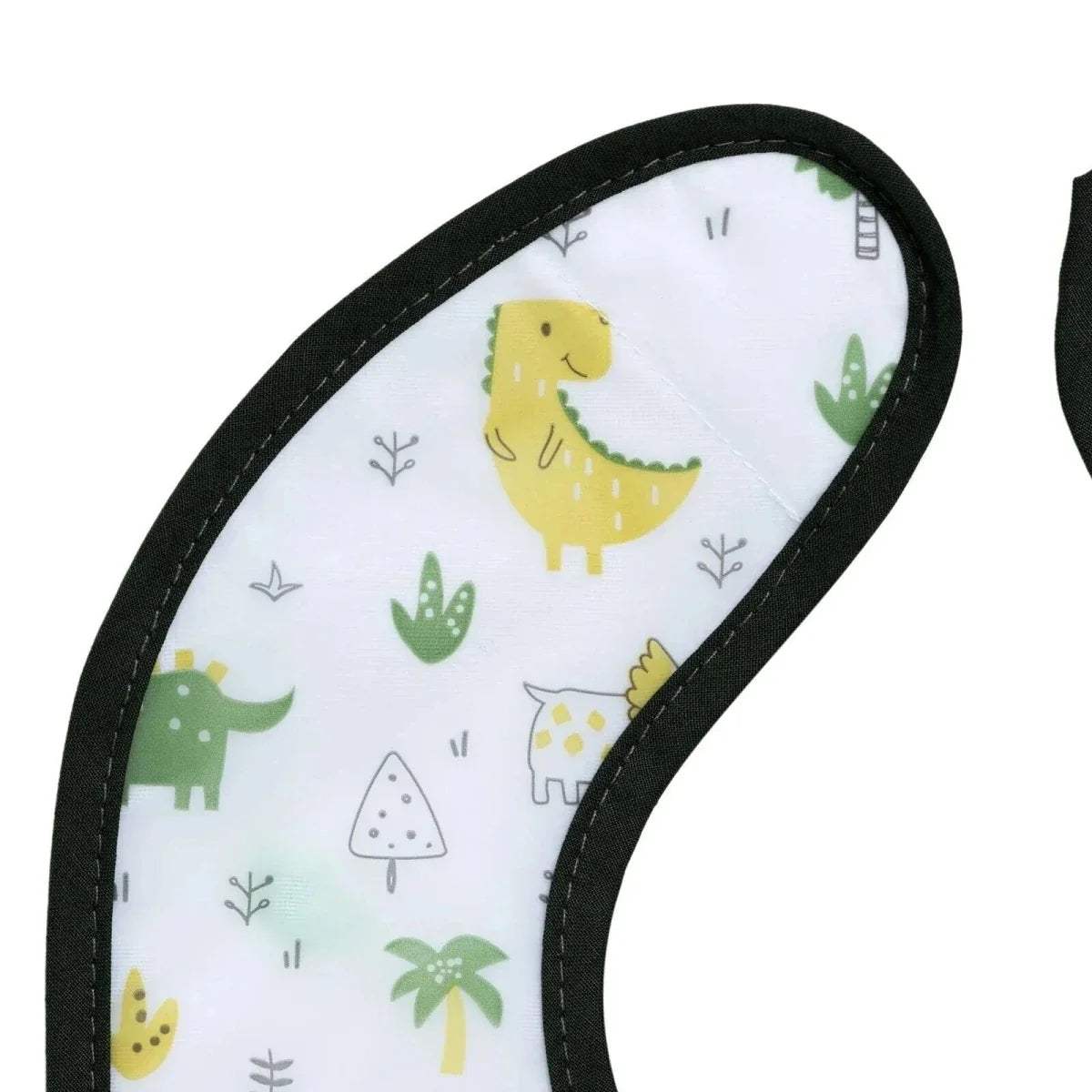 Close-up of white dinosaur baby bib with black edge stitching and playful animal print