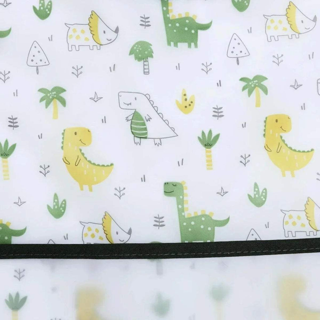 White baby bib fabric with repeating dinosaur and greenery prints and black trim border