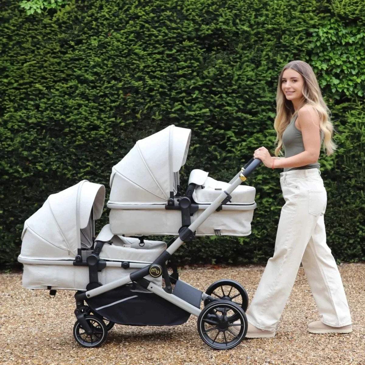 Ivory tandem pushchair with two seats, canopies, and four-wheel chassis