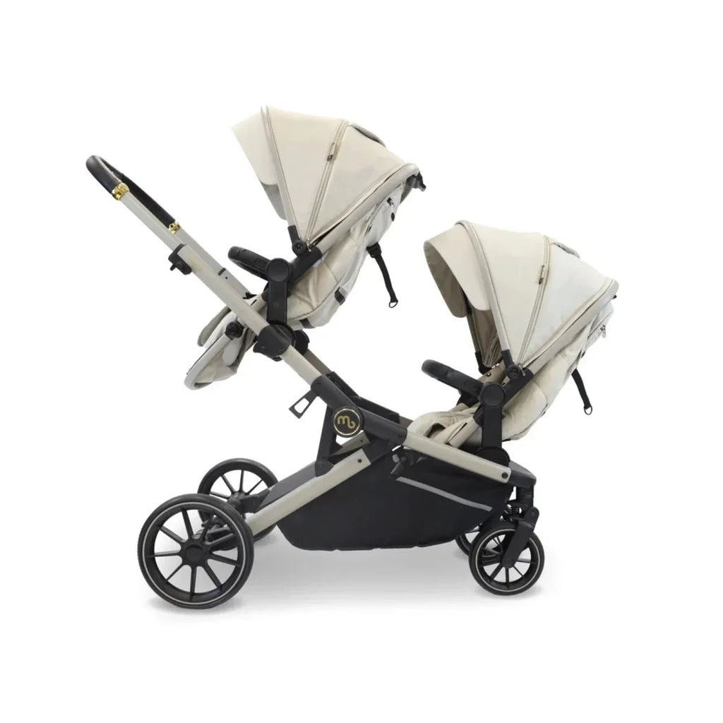 Ivory twin travel stroller with two carrycots, black seat panels, and large wheels