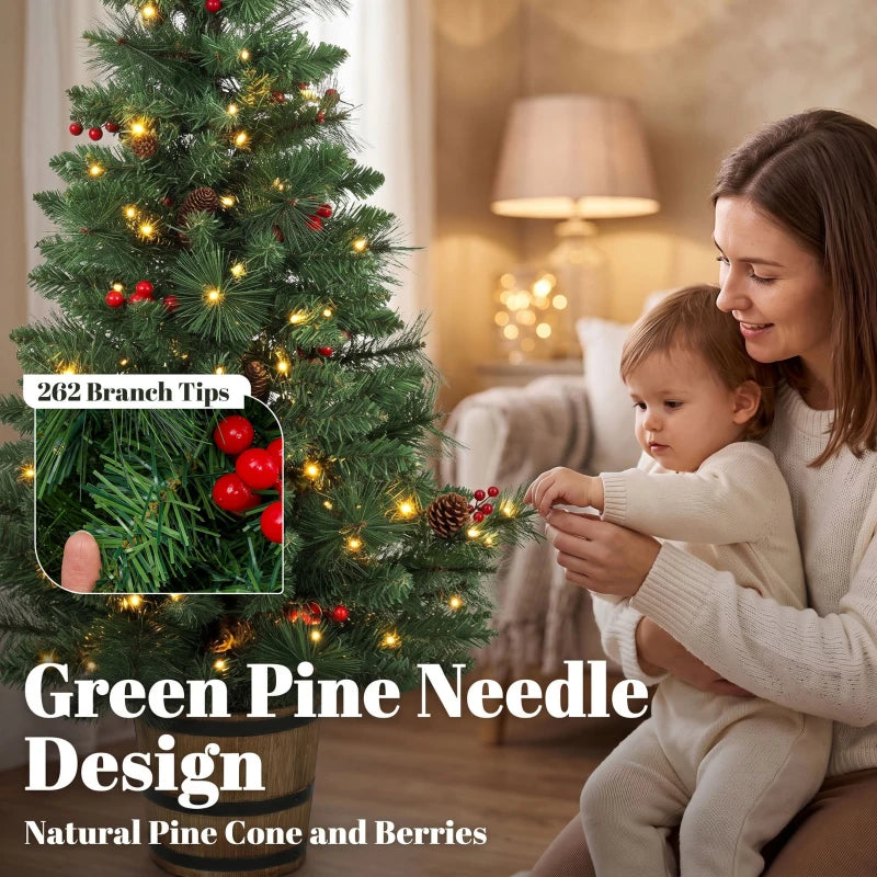 Green prelit Christmas tree in pot with pinecones, berries, and warm golden LED lights