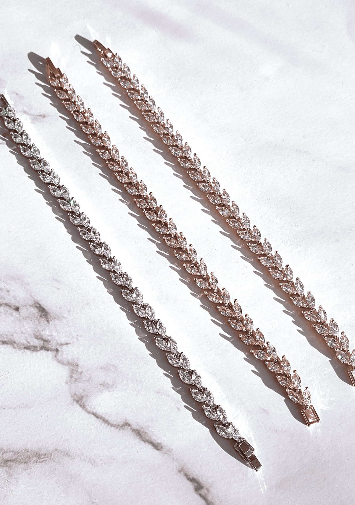 Marquise-cut petal bracelet with linked oval stones, slender chain, rose-gold tone.