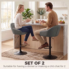 Grey bar stool with padded seat, curved backrest, and armrests on height-adjustable base