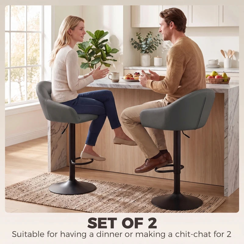 Grey bar stool with padded seat, curved backrest, and armrests on height-adjustable base