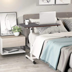 C-shaped over-bed table with brown top on wheeled base beside a bed