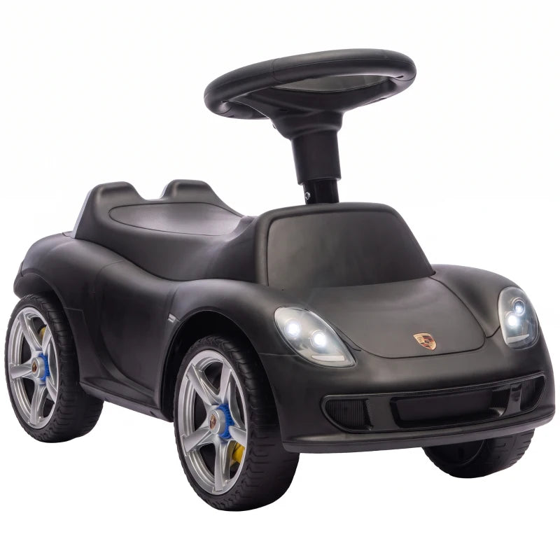 Matte black ride-on push car with front headlights, steering wheel, and molded seat