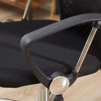 Black office chair seat with mesh panel and armrest support, close-up