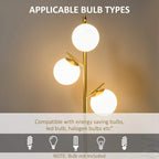 Gold three-light floor lamp with three round white globe shades