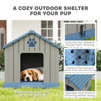 Grey outdoor dog kennel with blue roof, paw-print sign, and front door opening