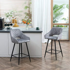 Grey velvet counter-height bar stools with black legs and diamond-quilted back