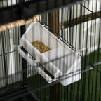 White removable tray inside black wire bird cage, filled with bird feed