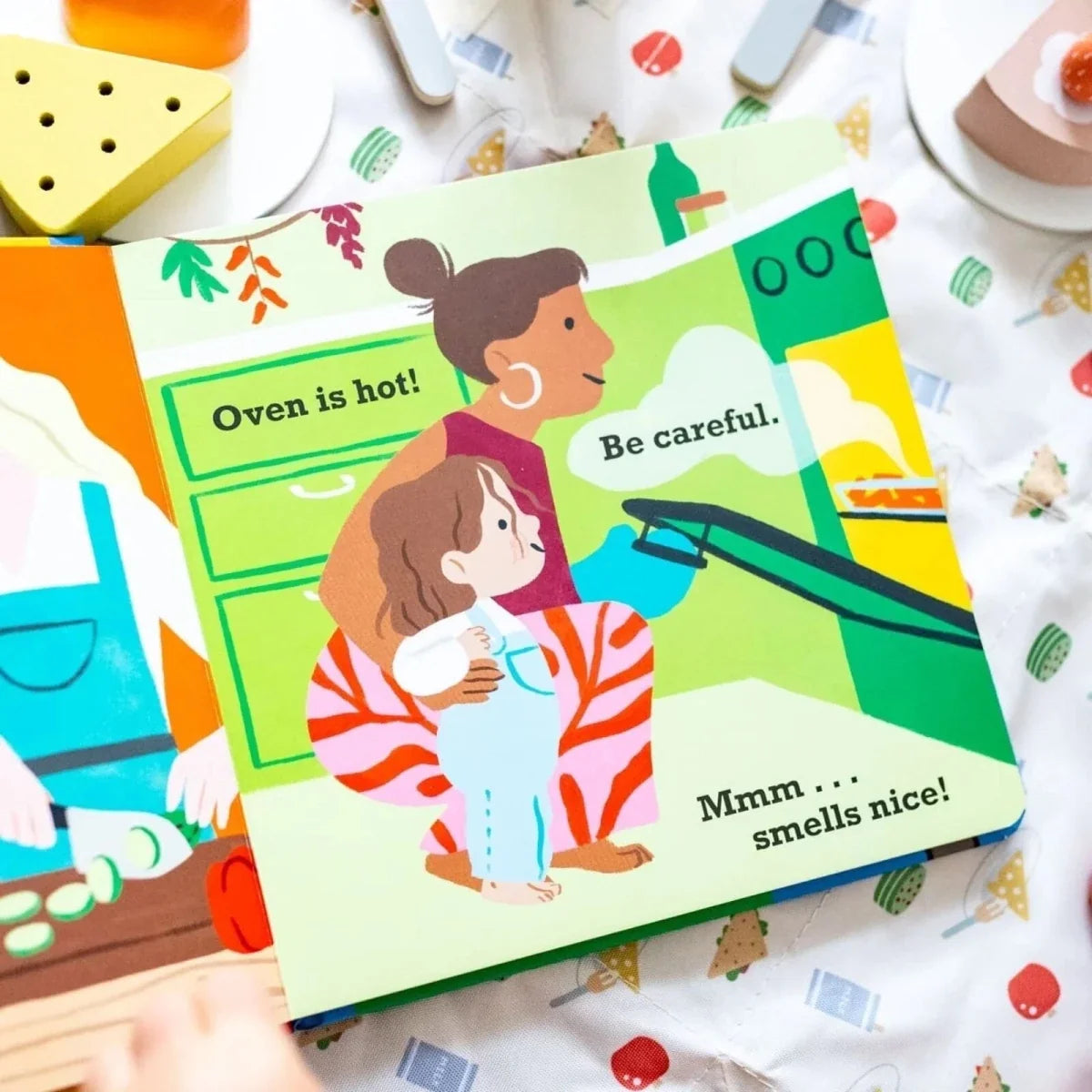 Illustrated Toddler Talk page with kids near oven, text says “Oven is hot”