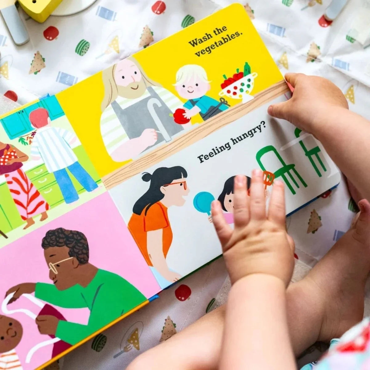 Illustrated Toddler Talk board book spread with food scene, “Feeling hungry?” text