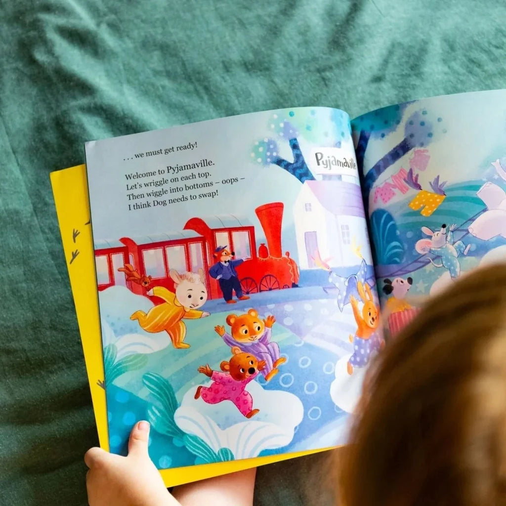 Open children's picture book with colorful train-themed illustrations and animals on pages
