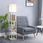 White floor lamp with acrylic shade and three-tier shelving beside a gray armchair