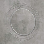 Silver round wall mirror with metal wire loop ring frame, close-up view